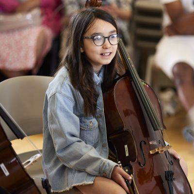 A girl holds a cello